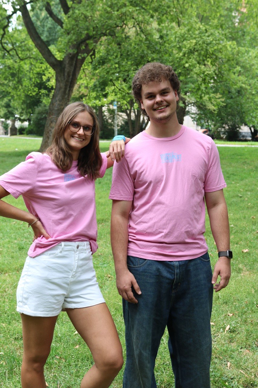 Zwei Personen tragen das pinke Turnfest-T-Shirt mit Logo auf der Brust