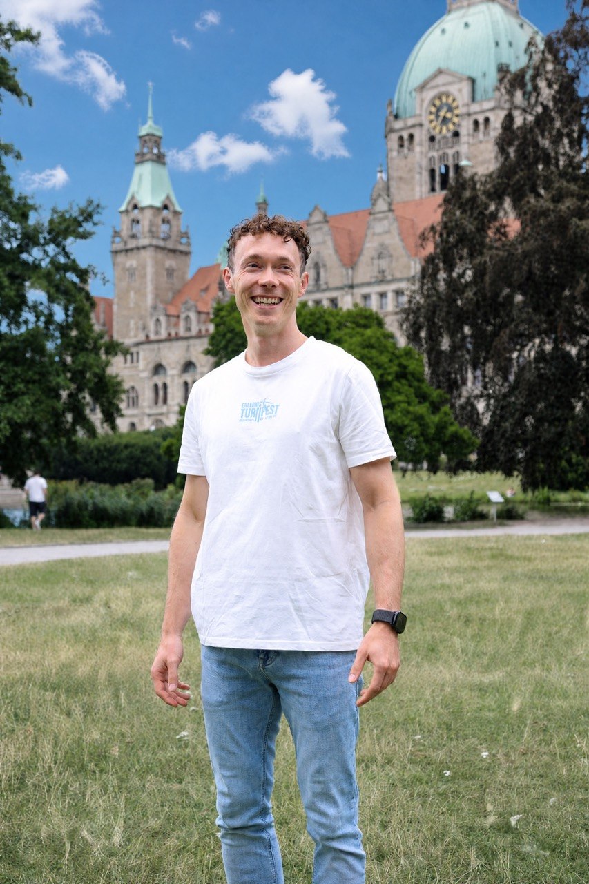 Person im weißen Turnfest-T-Shirt vor dem Braunschweiger Rathaus