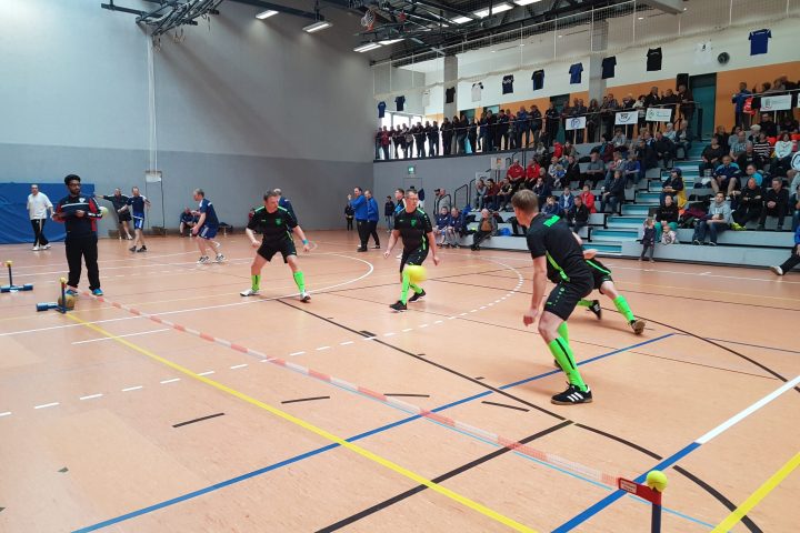 Prellballmannschaften spielen vor Zuschauer*innen während eines Hallenturniers.